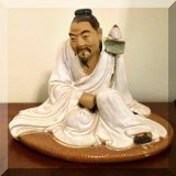 P03. Ceramic Asian ”Mud Man” holding a lotus. 8”h x 6.5”w - $42